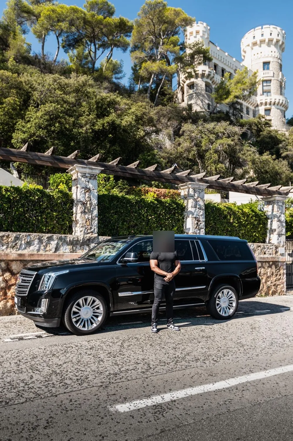 A black SUV in front of a white villa in the hills above Nice