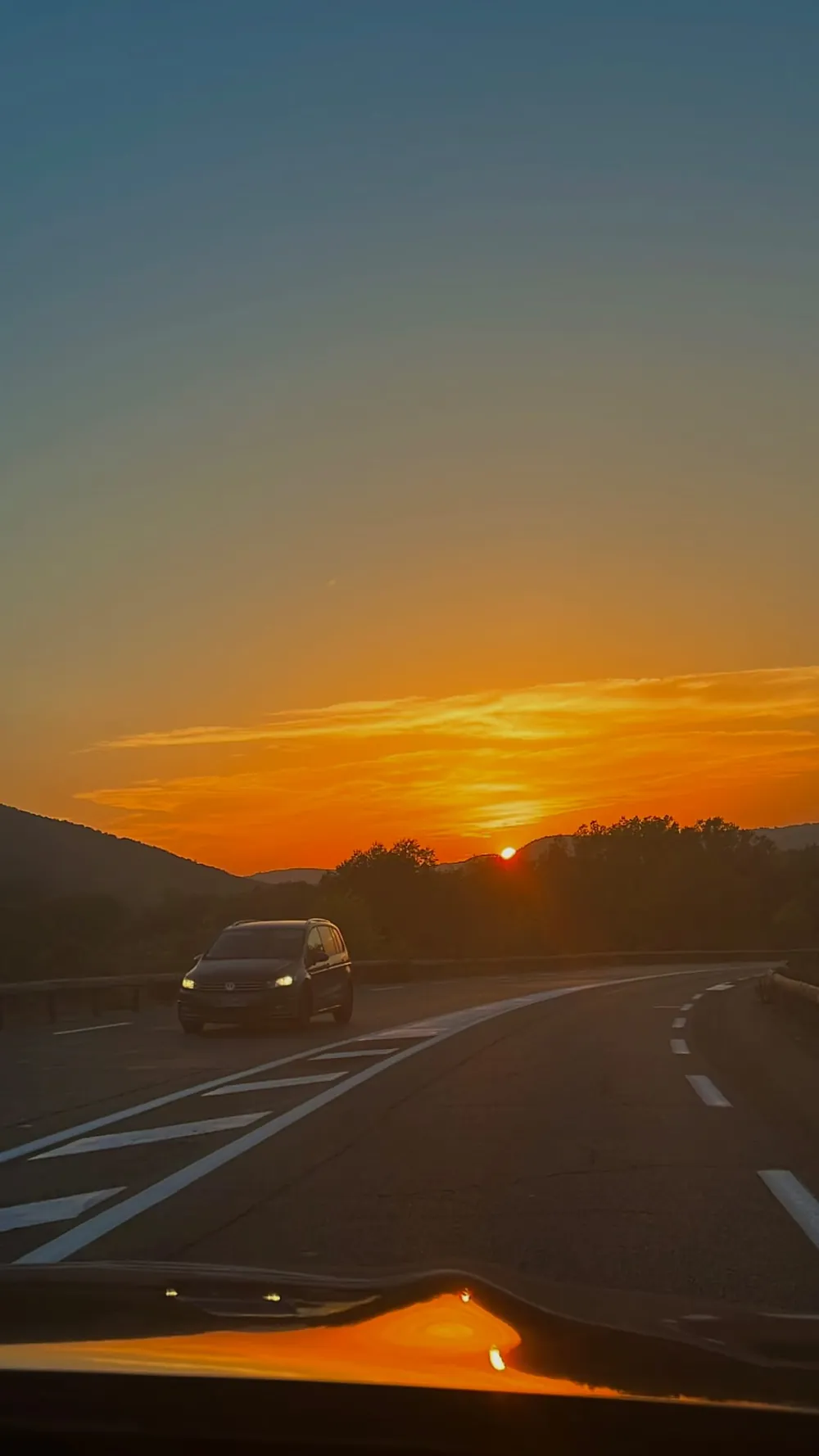 The road at sunset, seen from inside a car